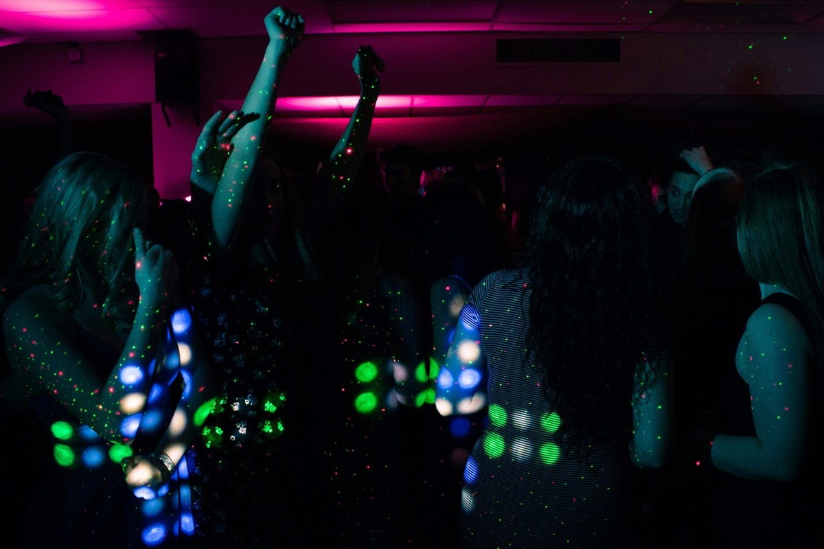 A silhouetted group of women dance in the club.